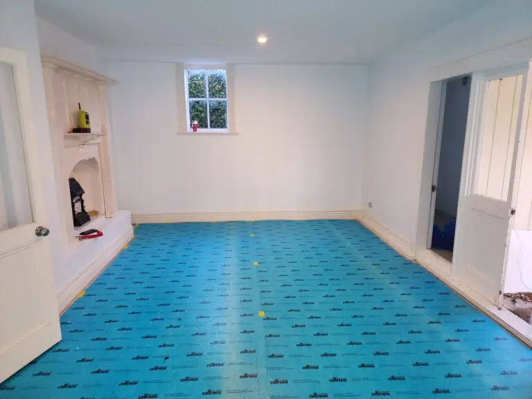 A plain white room before being carpeted, with a cleanly set up floor ready for it's carpeting services