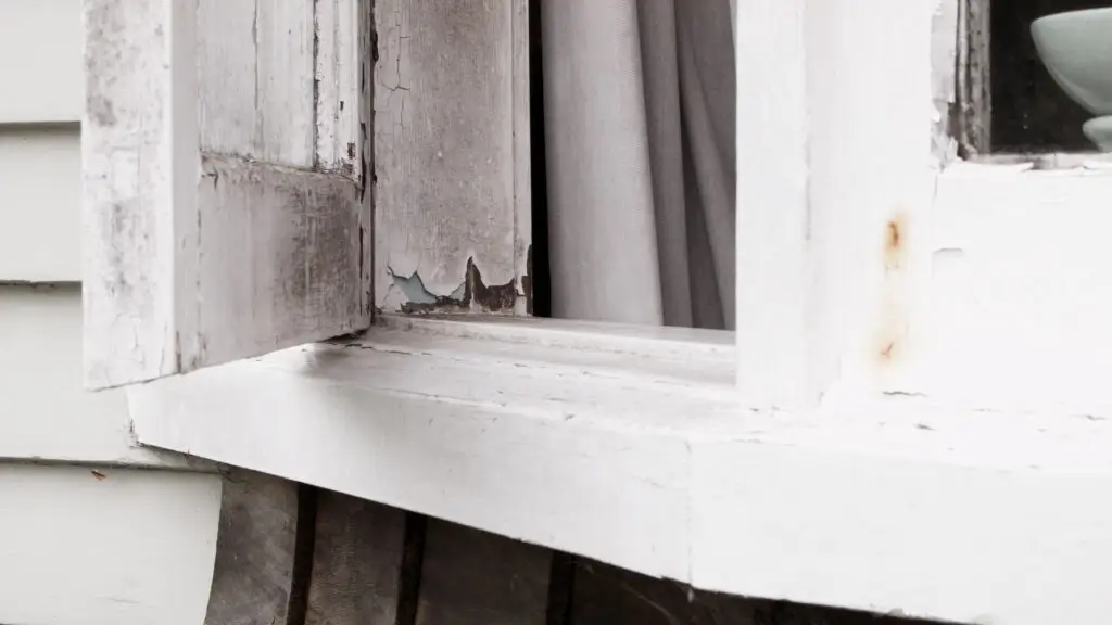 A window frame with cracked and decaying paint, removed and re-painted into a much improved look with window painting services by Market Ready