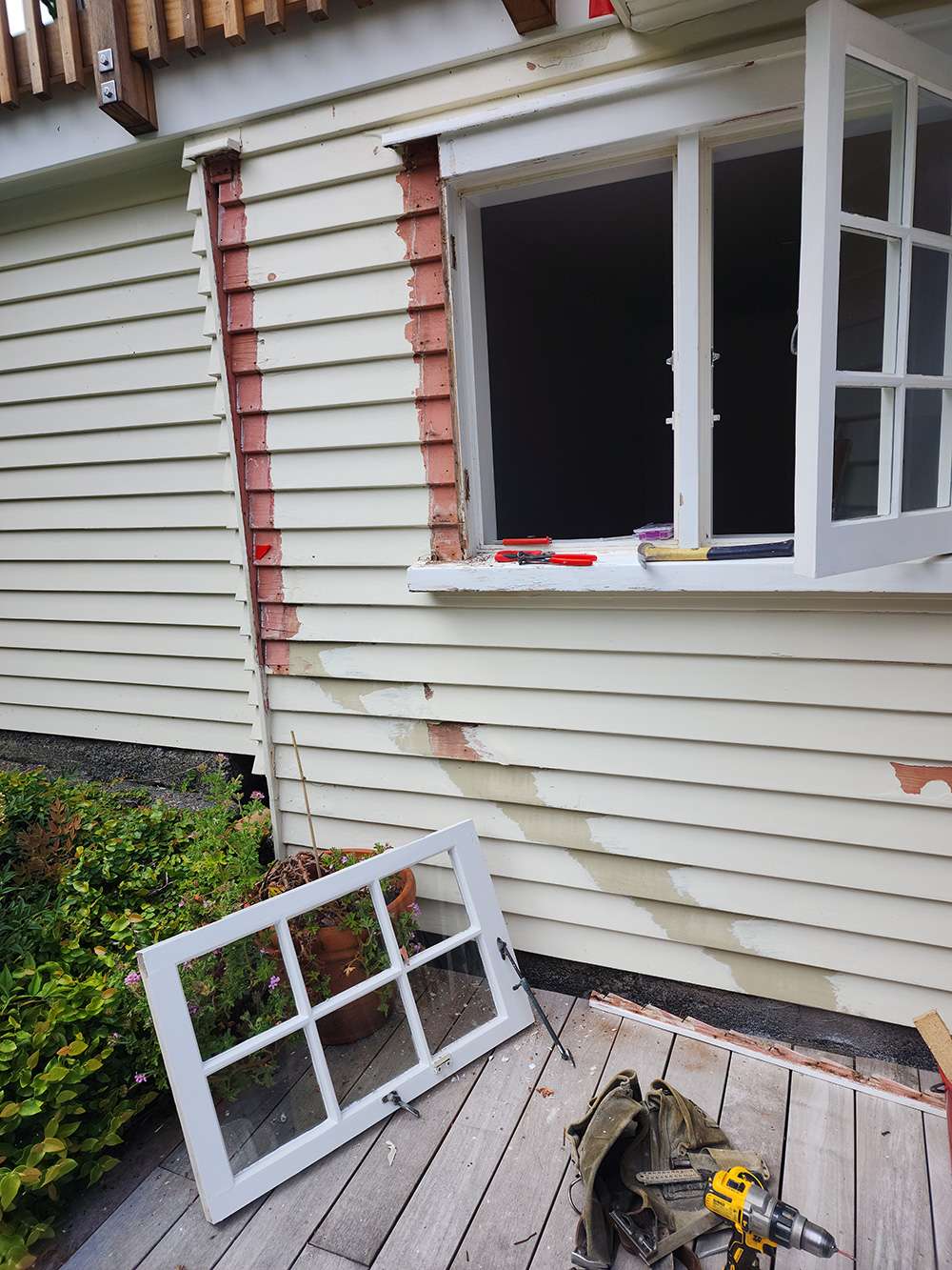 Window rot case study: Damaged window frame being repaired on a house with the window removed to show the damage.