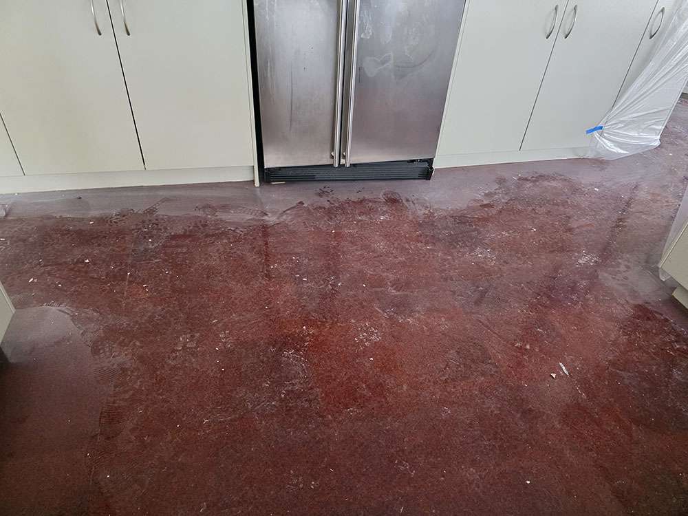 Kitchen with newly installed Lemonade-brand epoxy flooring in a rich, glossy brown finish. Modern, durable flooring solution.