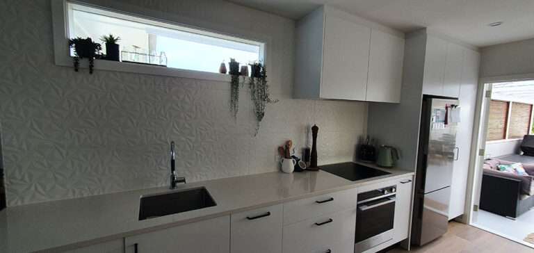 Bright new kitchen design with white cabinets, modern backsplash, stainless steel appliances, and stylish decor. New Kitchen 2