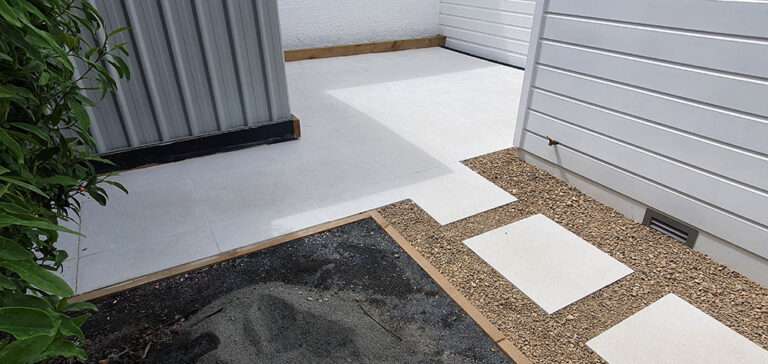Outdoor tiling patio featuring light gray tiles, gravel pathway, and a modern design. Perfect for backyard landscaping ideas.