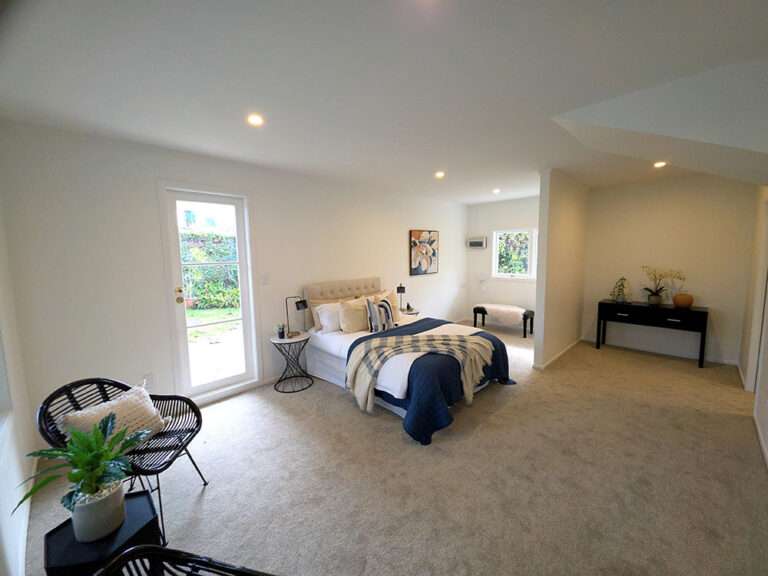 Modern bedroom interior with queen bed, stylish decor, and ample natural light. Room makeover design.