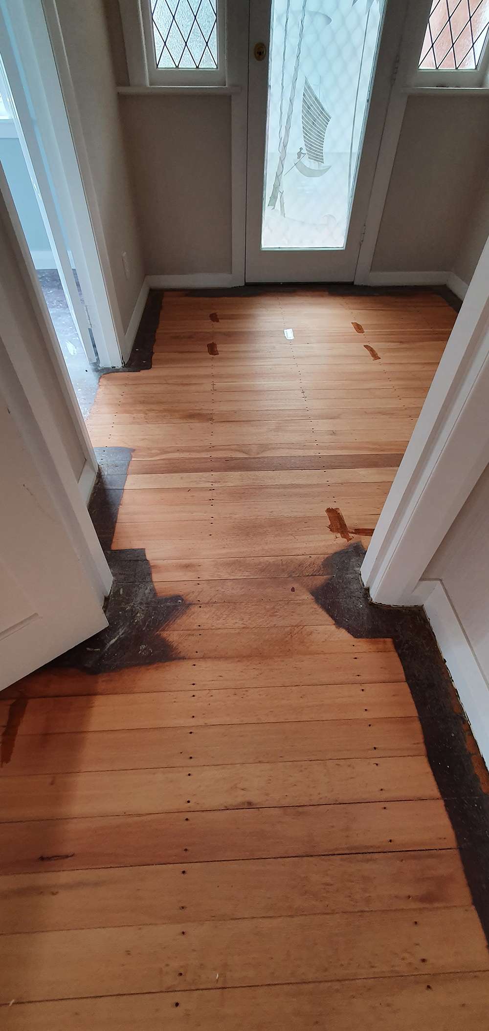 Timber floor refresh: Refinished hardwood flooring with light wood tones in a hallway. Professional floor restoration results.