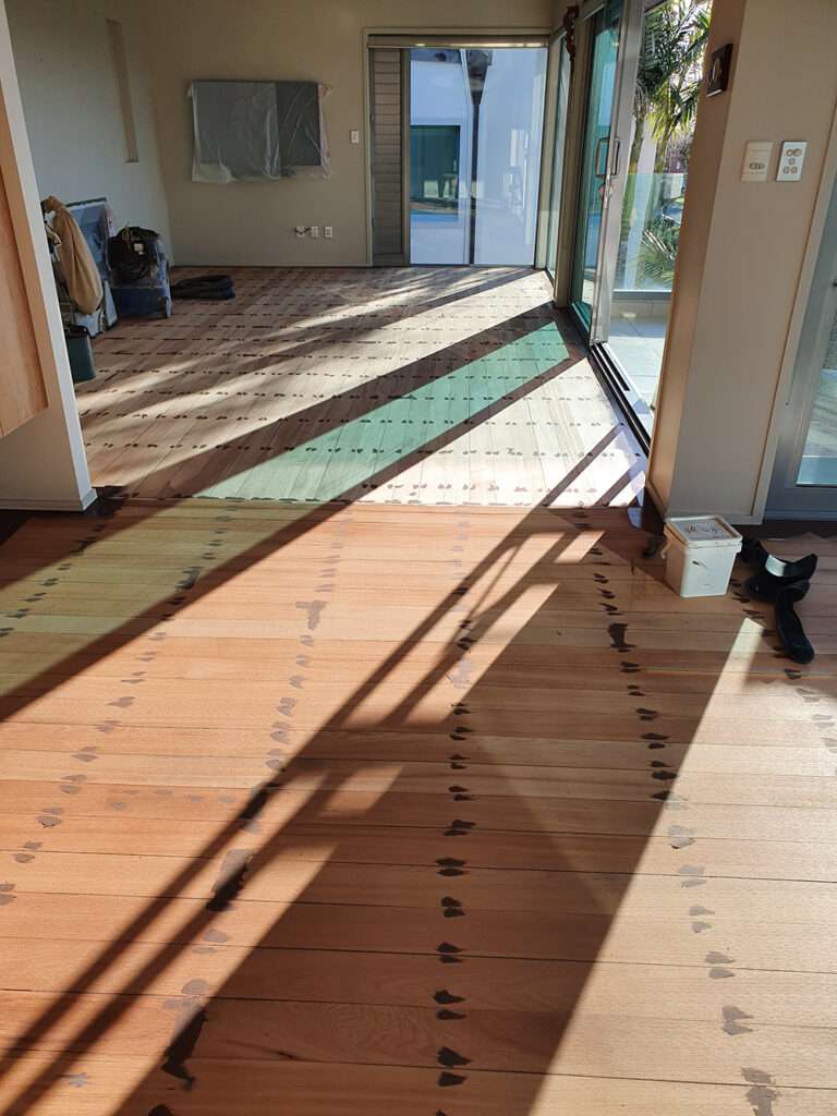 Timber floor refresh case study: Light-filled room featuring newly refreshed hardwood floors with a unique design pattern.