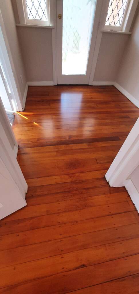 Refreshed timber floor. Shiny wooden flooring after professional timber floor refresh, showcasing rich color and smooth surface.