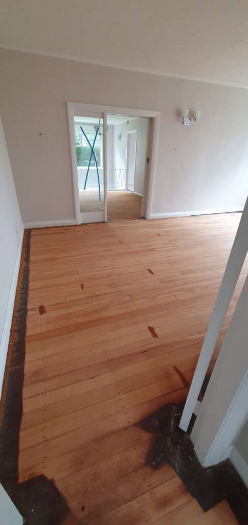 Timber floor refresh case study: Interior view of a room with newly refreshed hardwood flooring, showcasing its natural wood grain.