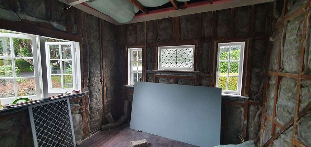 Interior wall insulation case study: Room with exposed studs and insulation, ready for drywall installation.