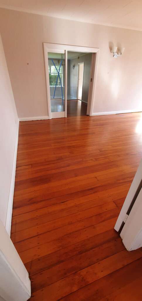Refreshed timber floor in a bright room, showcasing the wood grain after timber floor restoration. Timber Floor Refresh Case Study.