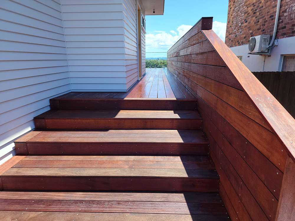 Decking handrail case study: Wooden deck stairs and handrail provide safe transition in outdoor space. Stylish wood design.