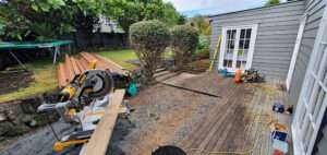 Kwila Decking Repair: Saw and wood planks for renovating a wooden deck in a residential backyard. Case study of decking project.