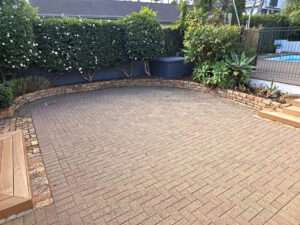 Brick releveling project showing a refreshed brick patio with re-laid bricks and neat garden edging.