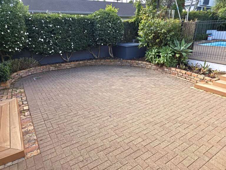Brick releveling project showing a refreshed brick patio with re-laid bricks and neat garden edging.