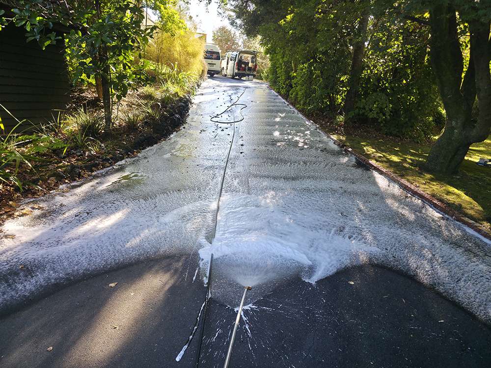 Moss and Mould Treatment in progress, driveway being cleaned with pressure washer, case study of moss removal.