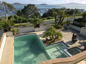 Pool painting project: Dirty swimming pool needing cleaning, painting & pump repair with ocean views. Case study from Auckland.