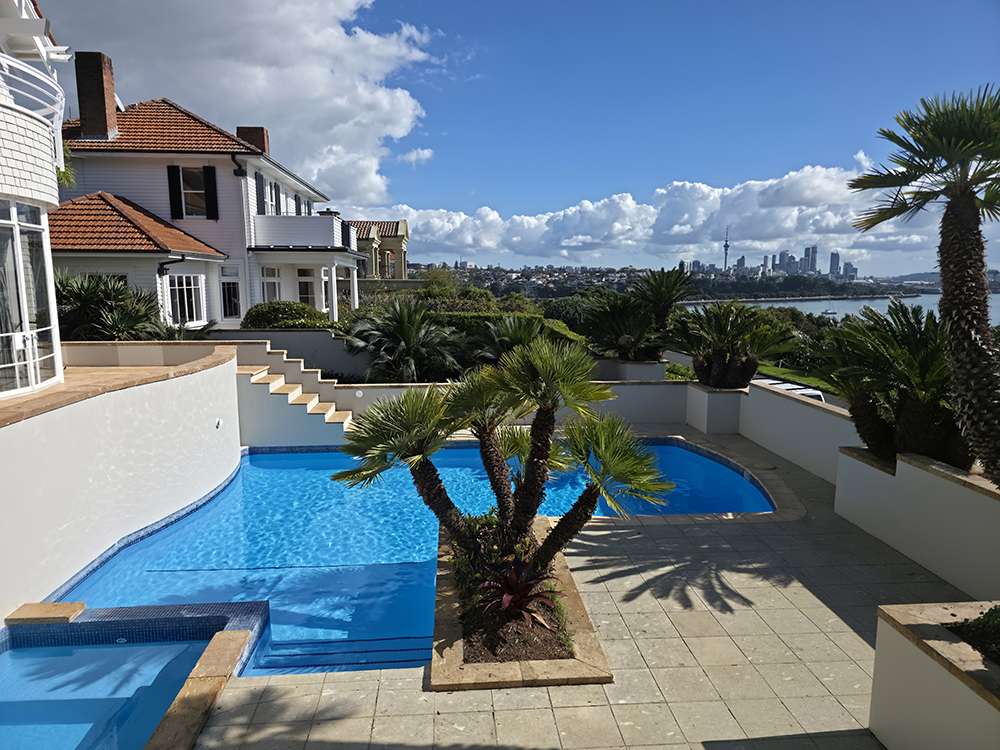 Pool painting project showcasing a luxurious pool with city views. Pool pump repair completed for optimal performance.