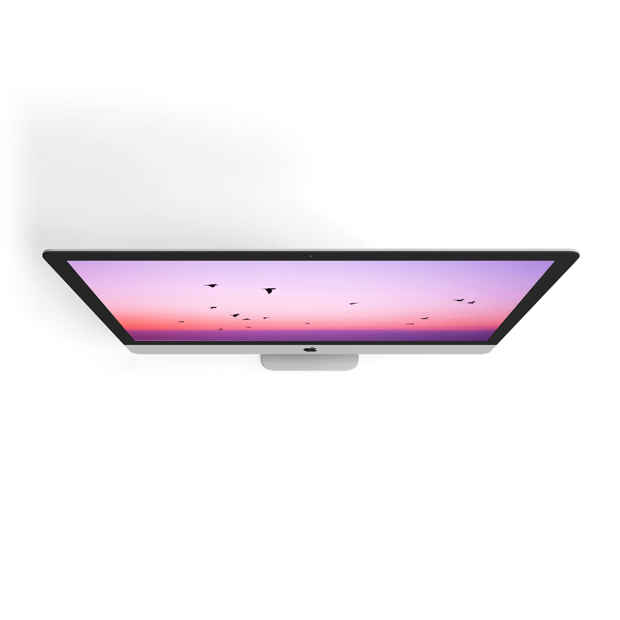 Overhead view of an Apple iMac featuring a vibrant sunset and silhouette birds on the screen. Modern desktop computer.